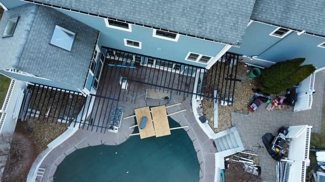 Aerial view of composite deck under construction next to an in-ground pool in Southern NH