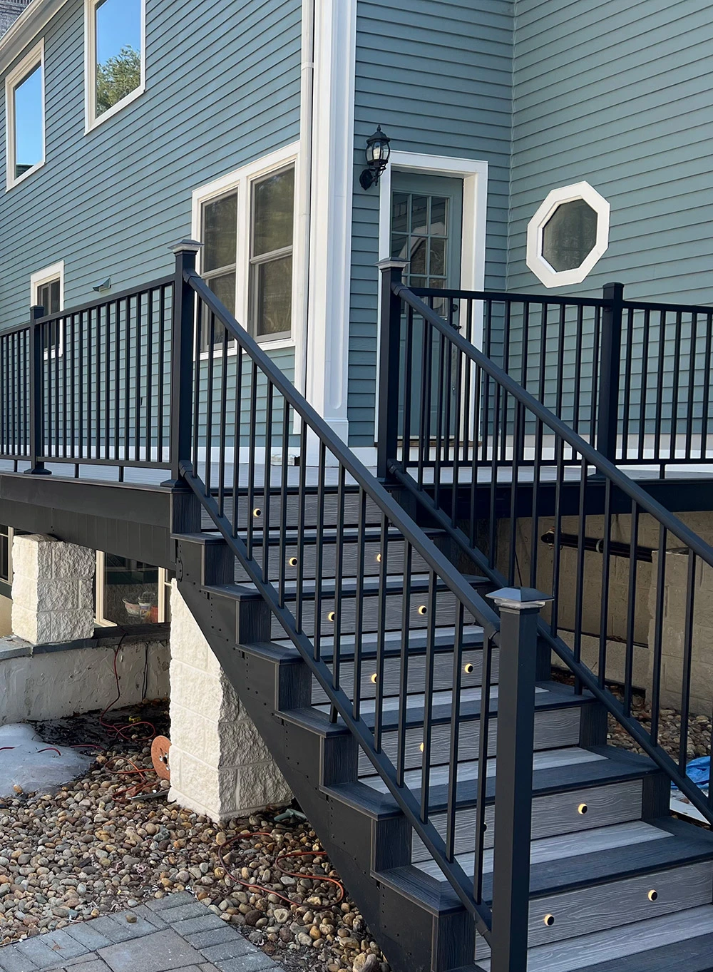 Elevated composite deck with black aluminum railing overlooking an in-ground pool in southern NH, aerial view